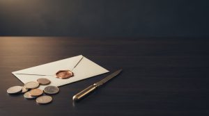 Cómo declarar dividendos de acciones de EE. UU. en la renta: monedas junto a un sobre lacrado y un abrecartas