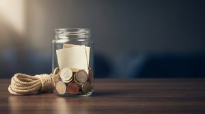 Fondo de emergencia: cuánto guardar y dónde tenerlo: un tarro con monedas y una cuerda enrollada